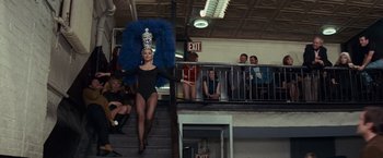 Movie still from “Valley of the Dolls” (1967), directed by Mark Robson – A woman in a black leotard and a blue feather headdress; Wide shot, Low angle