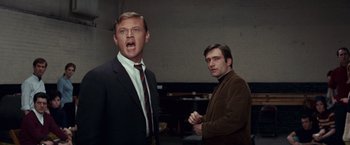 Movie still from “Valley of the Dolls” (1967), directed by Mark Robson – Two men in suits and ties standing next to each other in a room; Medium shot, Low angle