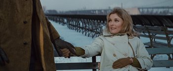 Movie still from “Valley of the Dolls” (1967), directed by Mark Robson – A woman in a white coat is shaking hands with a man in a brown jacket; Medium shot, Over the shoulder angle