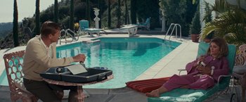 Movie still from “Valley of the Dolls” (1967), directed by Mark Robson – Two people sitting at the edge of a swimming pool; Wide shot, High angle