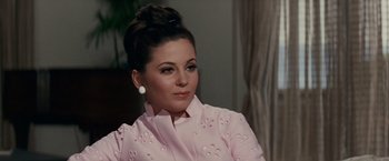 Movie still from “Valley of the Dolls” (1967), directed by Mark Robson – A woman in a pink jacket sitting in front of a window; Close Up shot, Over the shoulder angle