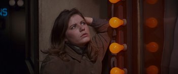 Movie still from “Valley of the Dolls” (1967), directed by Mark Robson – A woman standing in front of a wall of lights; Close Up shot, Low angle