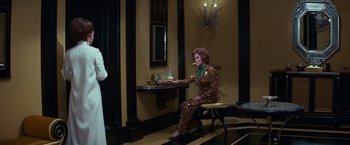 Movie still from “Valley of the Dolls” (1967), directed by Mark Robson – A woman sitting on a chair in a room; Wide shot, Over the shoulder angle