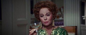 Movie still from “Valley of the Dolls” (1967), directed by Mark Robson – An older woman holding a wine glass in her right hand; Close Up shot, Over the shoulder angle