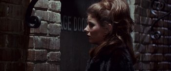 Movie still from “Valley of the Dolls” (1967), directed by Mark Robson – A person wearing a coat near a brick wall; Close Up shot, Over the shoulder angle