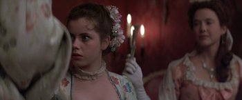 Movie still from “Valmont” (1989), directed by Milos Forman – A young woman holding a pair of candles in her hand; Close Up shot, Over the shoulder angle