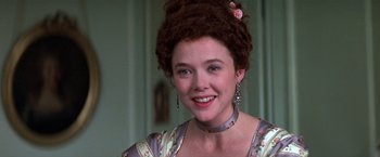 Movie still from “Valmont” (1989), directed by Milos Forman – A young woman with long curly brown hair wearing a floral dress; Close Up shot, Over the shoulder angle