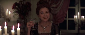 Movie still from “Valmont” (1989), directed by Milos Forman – A young woman holding a wine glass in her right hand; Close Up shot, High angle