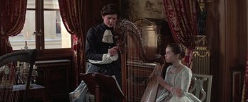 Movie still from “Valmont” (1989), directed by Milos Forman – A man and a woman playing a harp in a room; Medium shot, Over the shoulder angle
