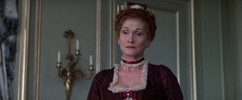 Movie still from “Valmont” (1989), directed by Milos Forman – An older woman wearing a red dress and a red bow; Close Up shot, Over the shoulder angle