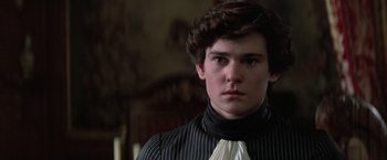 Movie still from “Valmont” (1989), directed by Milos Forman – A young man wearing a black and white striped shirt; Close Up shot, Over the shoulder angle