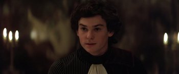 Movie still from “Valmont” (1989), directed by Milos Forman – A young man wearing a black and white striped shirt; Close Up shot, High angle