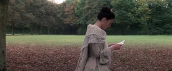 Movie still from “Valmont” (1989), directed by Milos Forman – A woman in a dress is looking at her phone; Medium shot, High angle