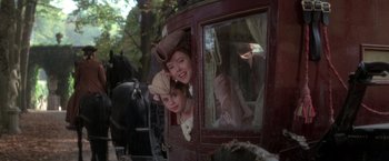 Movie still from “Valmont” (1989), directed by Milos Forman – Two people in a horse drawn carriage looking out of the window; Medium shot, Low angle