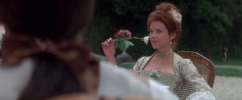 Movie still from “Valmont” (1989), directed by Milos Forman – A woman holding a rose in her hand and smiling; Close Up shot, Over the shoulder angle