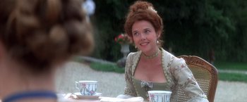 Movie still from “Valmont” (1989), directed by Milos Forman – A woman sitting at a table with two teacups in front of her; Medium shot, Over the shoulder angle