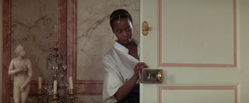 Movie still from “Valmont” (1989), directed by Milos Forman – A woman standing in front of a door; Medium shot, Over the shoulder angle