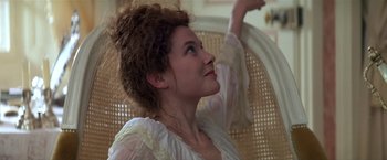 Movie still from “Valmont” (1989), directed by Milos Forman – A woman in a white dress is sitting on a chair; Close Up shot, Low angle