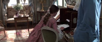 Movie still from “Valmont” (1989), directed by Milos Forman – A woman in a pink dress is playing the piano; Medium shot, High angle
