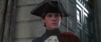 Movie still from “Valmont” (1989), directed by Milos Forman – A young man wearing a pirate's hat and holding an umbrella; Close Up shot, Over the shoulder angle