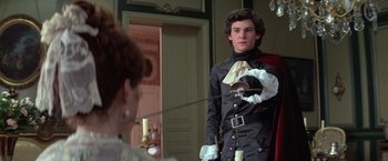 Movie still from “Valmont” (1989), directed by Milos Forman – A man wearing a suit and holding a sword in front of a mirror; Medium shot, Over the shoulder angle