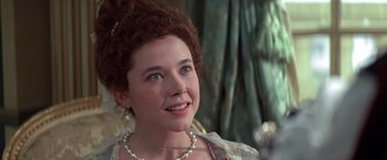Movie still from “Valmont” (1989), directed by Milos Forman – A young woman with a pearl necklace is smiling for the camera; Close Up shot, Over the shoulder angle