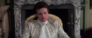 Movie still from “Valmont” (1989), directed by Milos Forman – A man sitting in a chair wearing a white shirt and tie; Close Up shot, Low angle