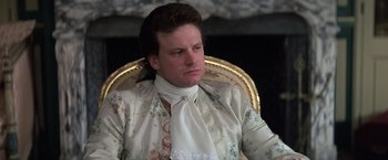 Movie still from “Valmont” (1989), directed by Milos Forman – A man sitting in a chair wearing a floral shirt; Close Up shot, Over the shoulder angle