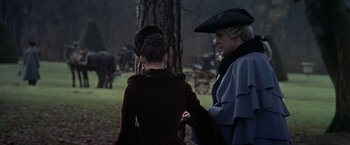 Movie still from “Valmont” (1989), directed by Milos Forman – A man and a woman dressed in period clothing stand in front of a tree; Medium shot, Over the shoulder angle
