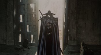 Movie still from “Vampire Hunter D: Bloodlust” (2000), directed by Yoshiaki Kawajiri – A man in a black cloak and a black hat with a sword; Wide shot, Low angle