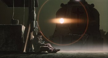 Movie still from “Vampire Hunter D: Bloodlust” (2000), directed by Yoshiaki Kawajiri – A man sitting on the ground next to a train; Wide shot, Low angle