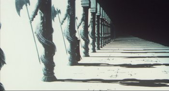 Movie still from “Vampire Hunter D: Bloodlust” (2000), directed by Yoshiaki Kawajiri – A row of metal poles on the side of the street; Extreme Wide shot, Low angle