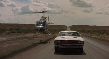 Movie still from “Vanishing Point” (1971), directed by Richard C. Sarafian – A car and a helicopter on a road; Wide shot, Low angle