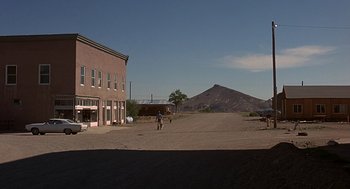 Movie still from “Vanishing Point” (1971), directed by Richard C. Sarafian – An empty street with a horse and rider in the middle of the day; Extreme Wide shot, Over the shoulder angle