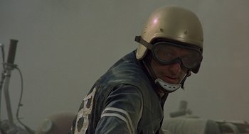 Movie still from “Vanishing Point” (1971), directed by Richard C. Sarafian – A man wearing a helmet and riding a motorcycle; Close Up shot, Low angle