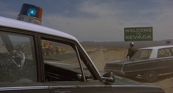 Movie still from “Vanishing Point” (1971), directed by Richard C. Sarafian – A car parked on the side of a road; Extreme Wide shot, Low angle