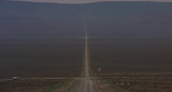 Movie still from “Vanishing Point” (1971), directed by Richard C. Sarafian – An empty dirt road in the middle of a field; Extreme Wide shot, High angle