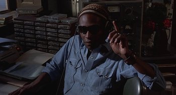 Movie still from “Vanishing Point” (1971), directed by Richard C. Sarafian – A man wearing sunglasses and a hat is listening to music; Close Up shot, Low angle