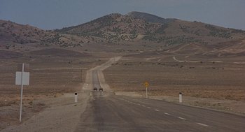 Movie still from “Vanishing Point” (1971), directed by Richard C. Sarafian – An empty road in the middle of the desert; Extreme Wide shot, High angle
