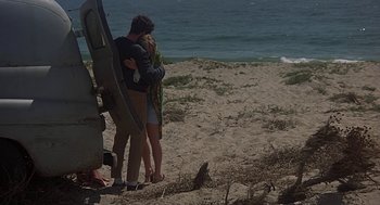 Movie still from “Vanishing Point” (1971), directed by Richard C. Sarafian – A man and a woman hugging on the beach; Wide shot, High angle