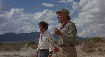 Movie still from “Vanishing Point” (1971), directed by Richard C. Sarafian – Two men standing in the desert talking to each other; Wide shot, Low angle