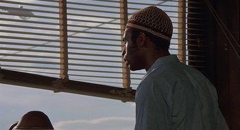 Movie still from “Vanishing Point” (1971), directed by Richard C. Sarafian – A man wearing a hat standing next to a window; Close Up shot, Low angle