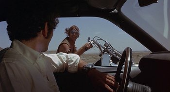 Movie still from “Vanishing Point” (1971), directed by Richard C. Sarafian – A man and a woman driving a car in the desert; Medium shot, Over the shoulder angle