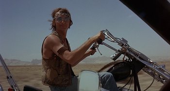 Movie still from “Vanishing Point” (1971), directed by Richard C. Sarafian – A man on a motor bike in the middle of the desert; Medium shot, Low angle