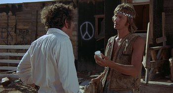Movie still from “Vanishing Point” (1971), directed by Richard C. Sarafian – Two men are standing outside talking to each other; Medium shot, Low angle