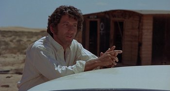 Movie still from “Vanishing Point” (1971), directed by Richard C. Sarafian – A man sitting on the hood of a white car; Close Up shot, Low angle