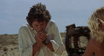 Movie still from “Vanishing Point” (1971), directed by Richard C. Sarafian – A man in a white shirt is eating something; Close Up shot, Low angle