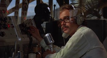 Movie still from “Vanishing Point” (1971), directed by Richard C. Sarafian – A man with headphones and a microphone in his hand; Close Up shot, Low angle