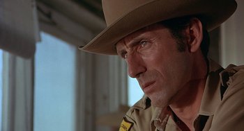 Movie still from “Vanishing Point” (1971), directed by Richard C. Sarafian – A person wearing a hat; Close Up shot, Over the shoulder angle