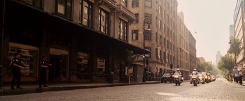 Movie still from “Vantage Point” (2008), directed by Pete Travis – People are standing on the side of the street; Extreme Wide shot, High angle